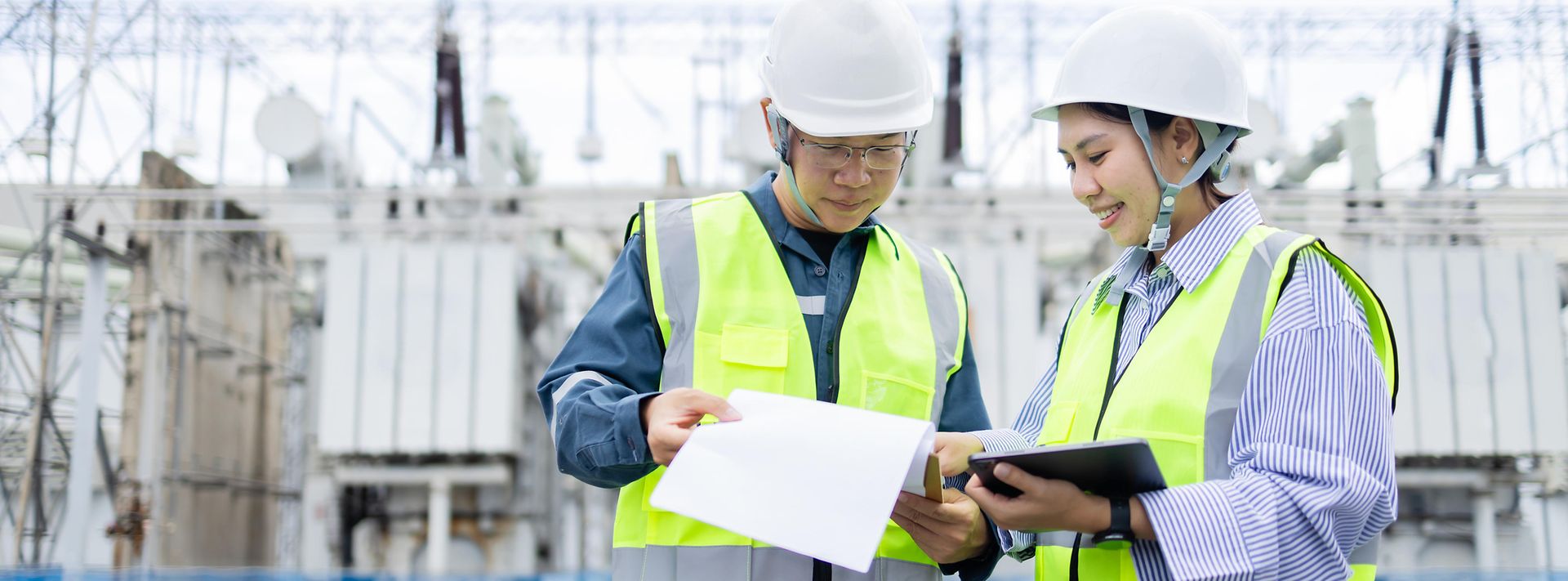 Zwei Arbeiter vor einer Umspannanlage 