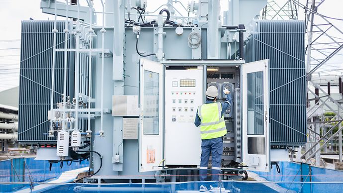 Techniker an einem Schaltschrank einer Umspannanlage