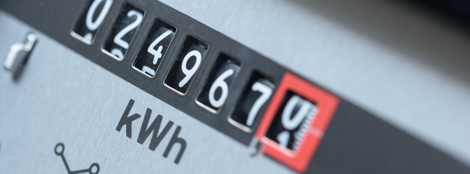 Nahaufnahme eines analogen Stromzählers, dessen Rollenzähler den aktuellen kWh-Verbrauch anzeigt.