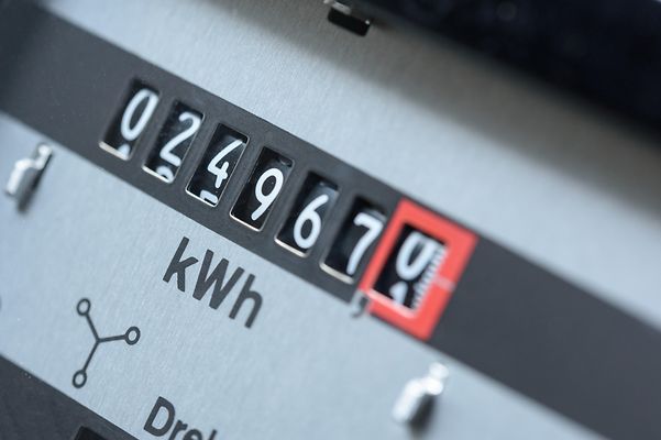 Nahaufnahme eines analogen Stromzählers, dessen Rollenzähler den aktuellen kWh-Verbrauch anzeigt.